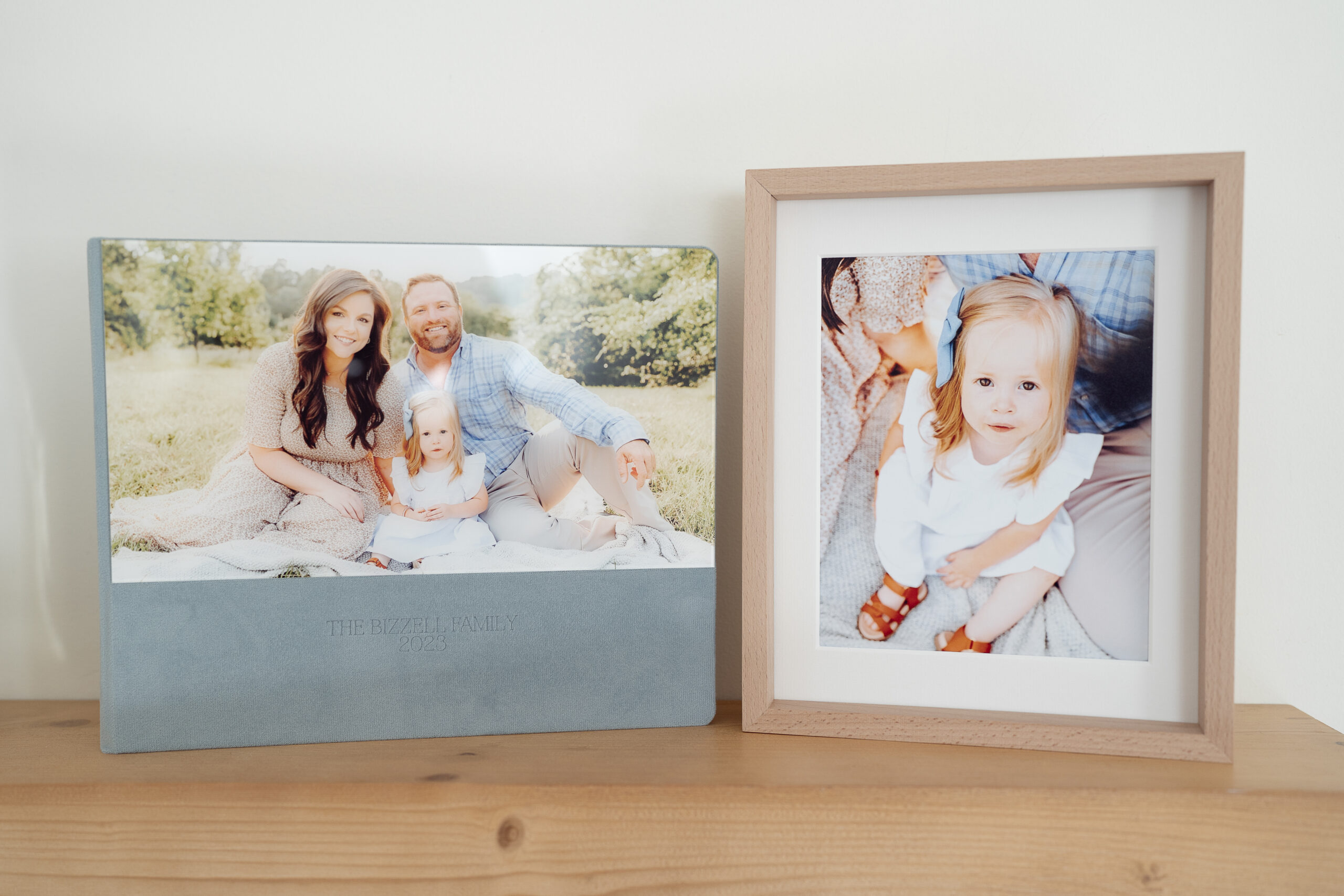 A display of family photos inside a folio box with one print in an interchangeable frame